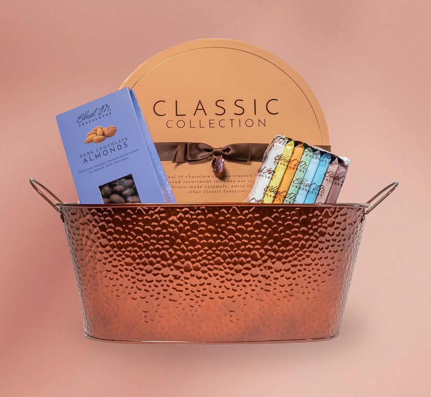 Ethel M Chocolates gift basket on a pink background