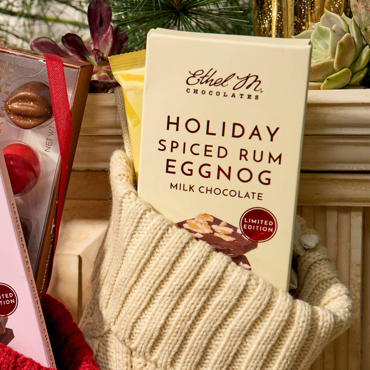 Ethel M Chocolates Holiday Milk Chocolate Spiced Rum Eggnog Bar Lifestyle Image - Shows the bar in a yellow stocking hanging from the mantle 