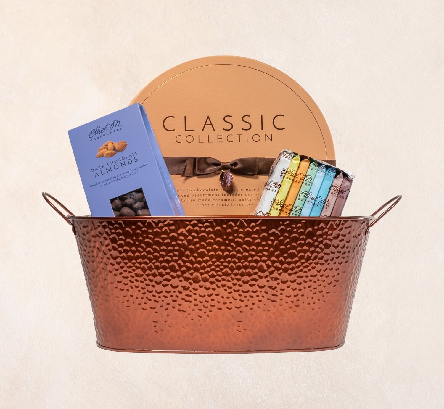 Ethel M Chocolates Classic Gift Basket on a light tan background.
